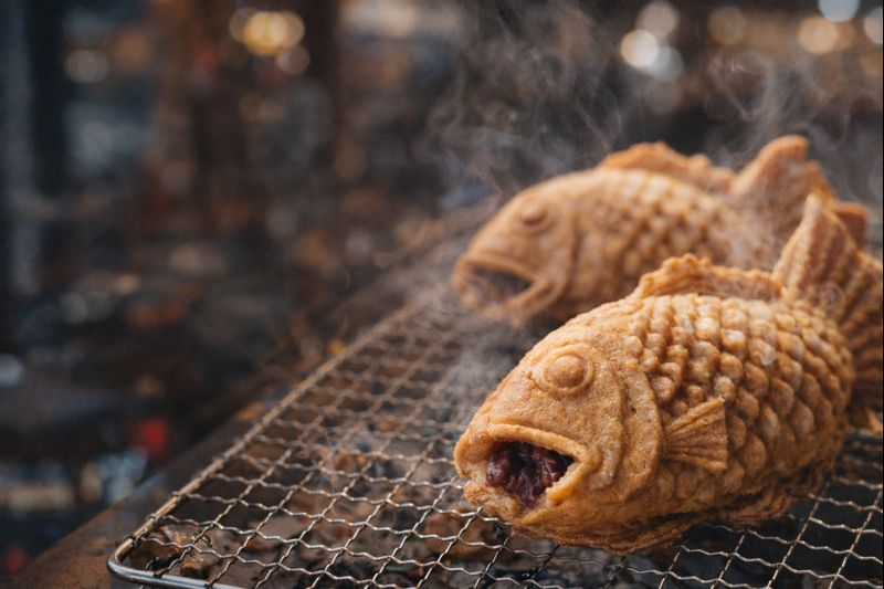 석쇠 위에 노릇노릇한 붕어빵이 올라가 있는 이미지.